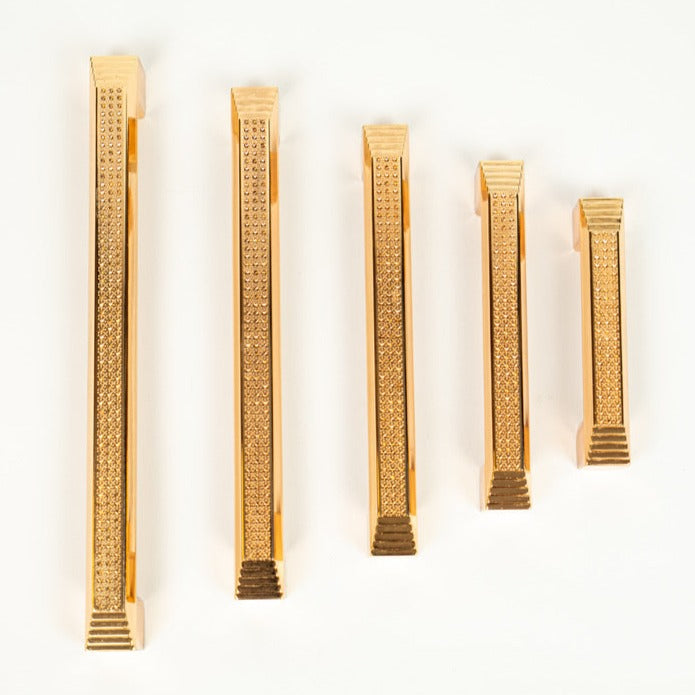 A collection of rose gold cabinet pulls of varying sizes displayed on a white background.
