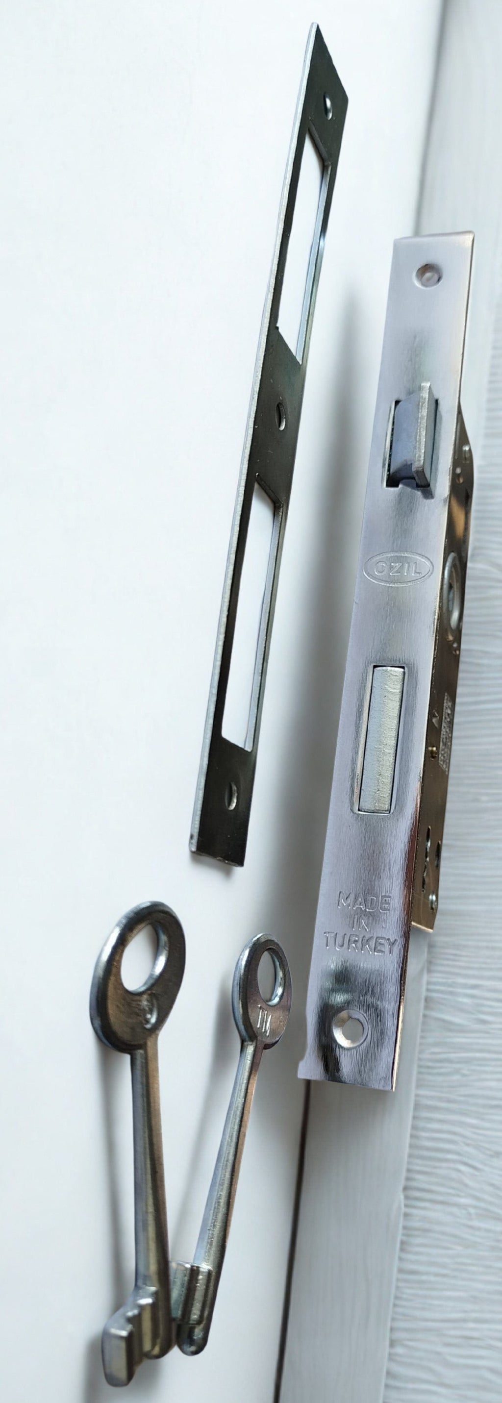 Metal door handle and lock mechanism on a white background