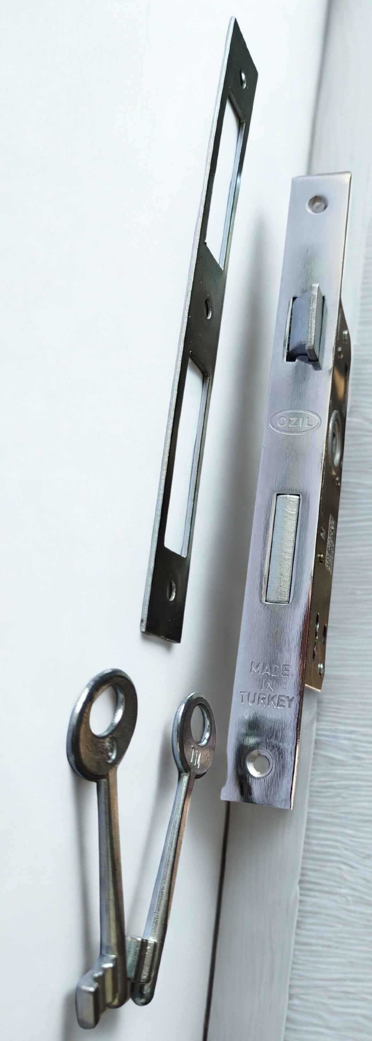 Metal door handle and lock mechanism on a white background