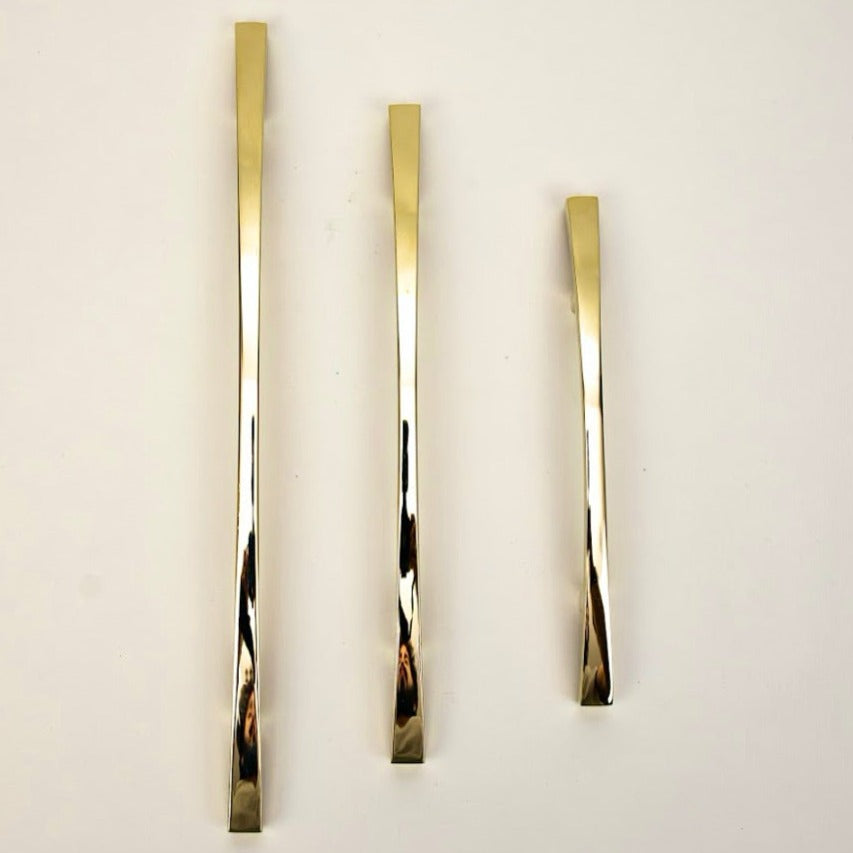 A set of three gold-colored metal cabinet pulls of different lengths placed against a white background.