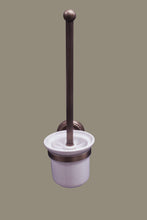 Load image into Gallery viewer, A wall-mounted toilet brush holder with a brass finish and a white ceramic base.
