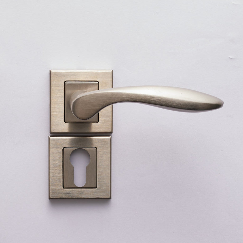 A modern silver cylinder door handle with a keyhole, mounted on a white door.