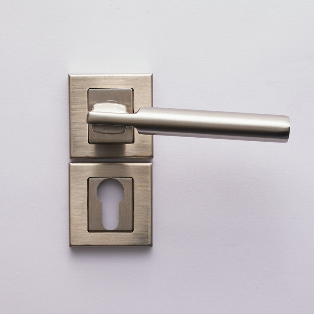 A silver cylinder door handle with a keyhole escutcheon on a white door.