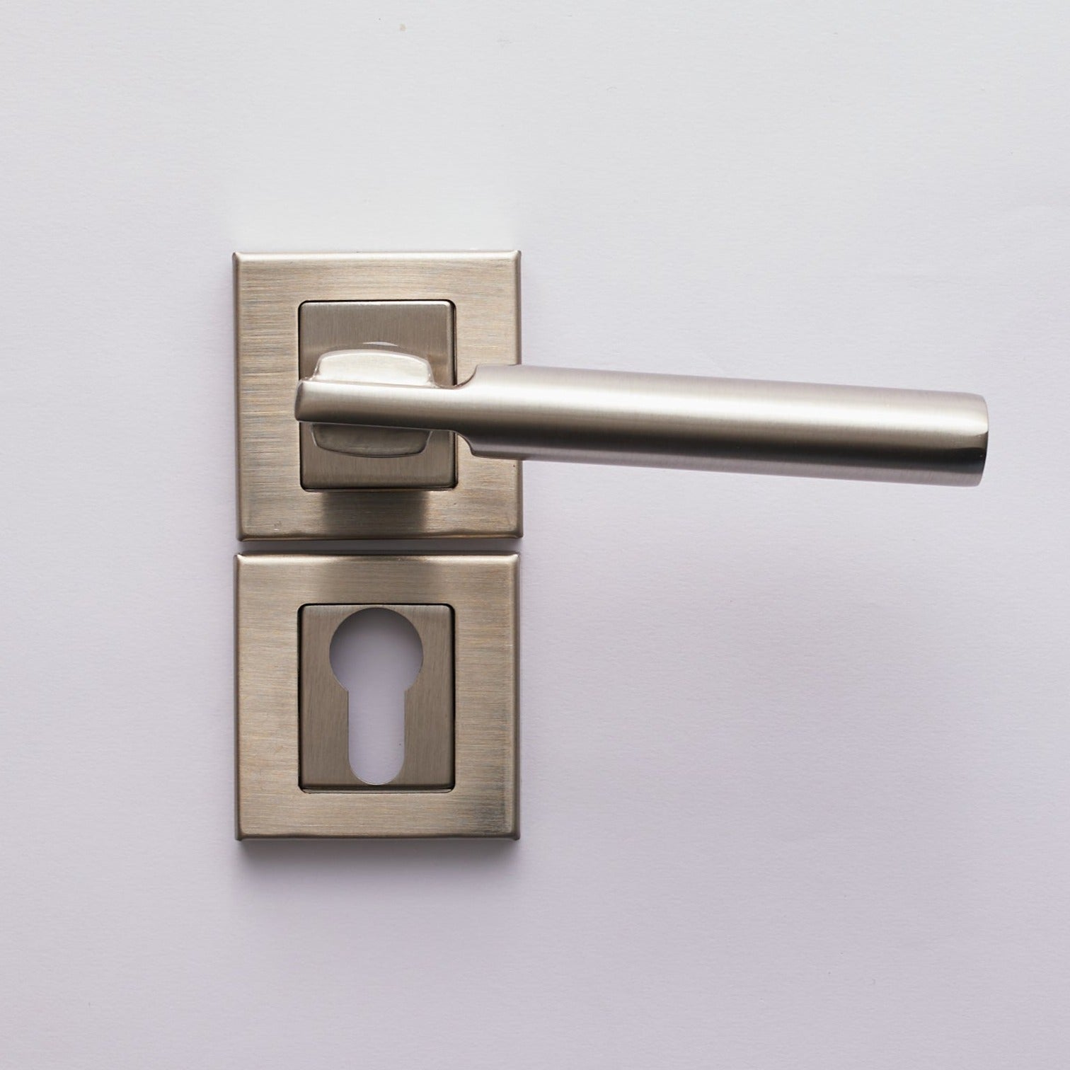 A silver cylinder door handle with a keyhole escutcheon on a white door.