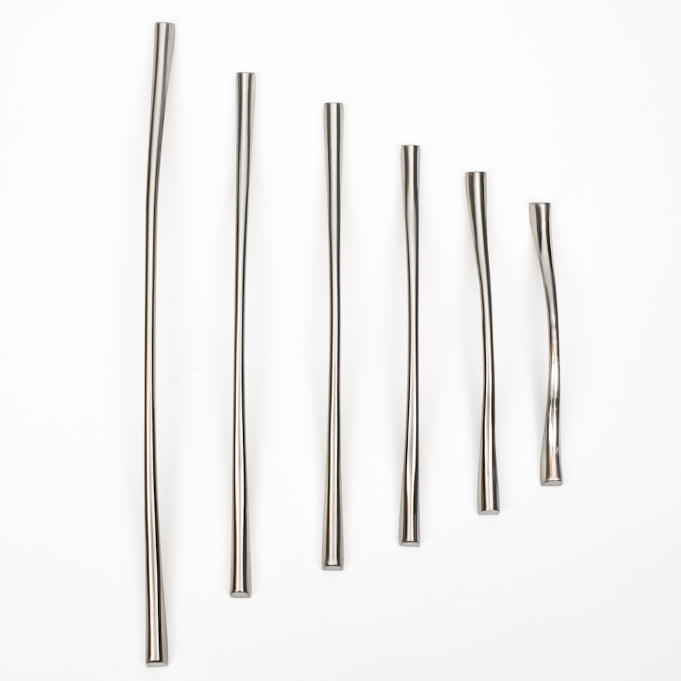 A collection of silver matte cabinet pulls of various sizes laid out on a white surface.
