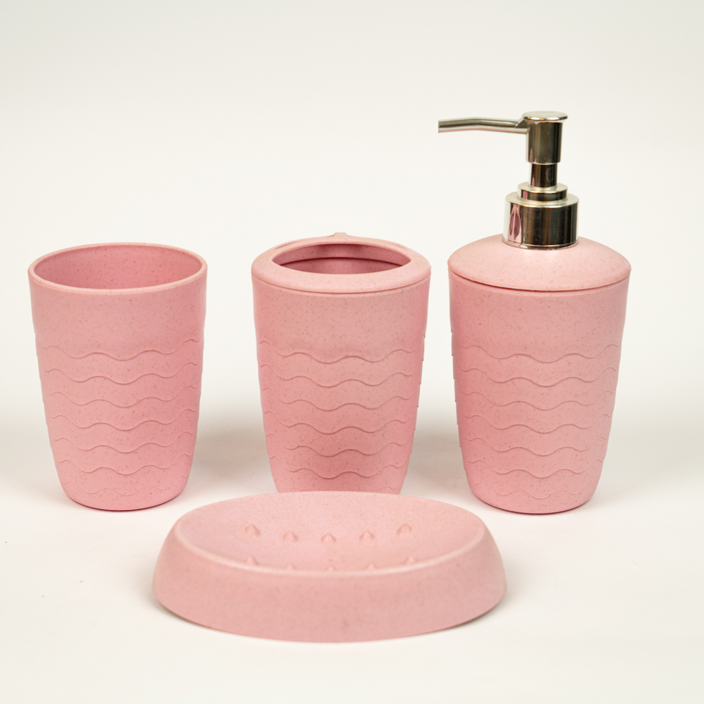 A set of pink acrylic bathroom accessories, including a soap dish, a toilet brush holder, and a tray.
