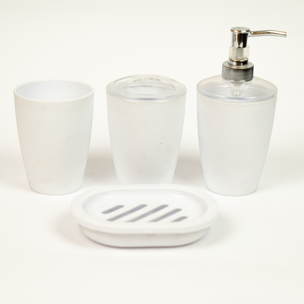 A set of white acrylic bathroom accessories including a soap dispenser, two cups, and a soap dish.