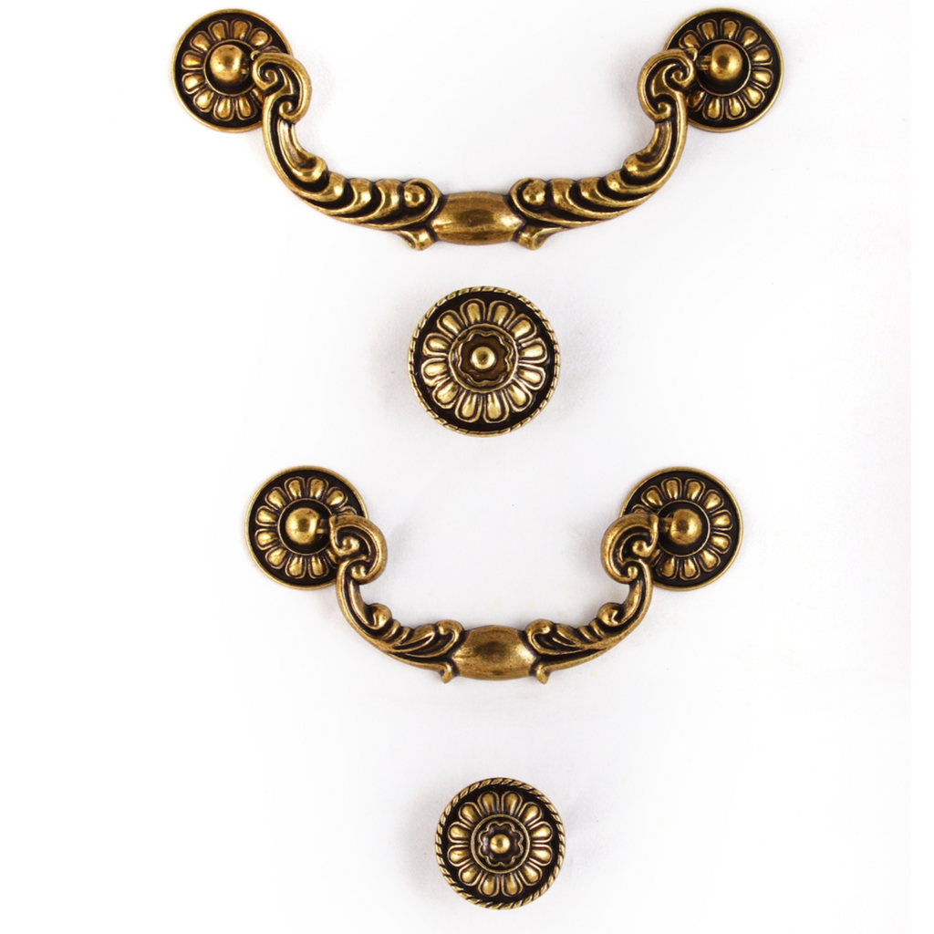 A set of three brass door knobs with decorative floral patterns, displayed against a white background.