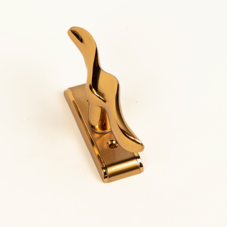 A gold-colored window handle made of zinc alloy, displayed against a white background.