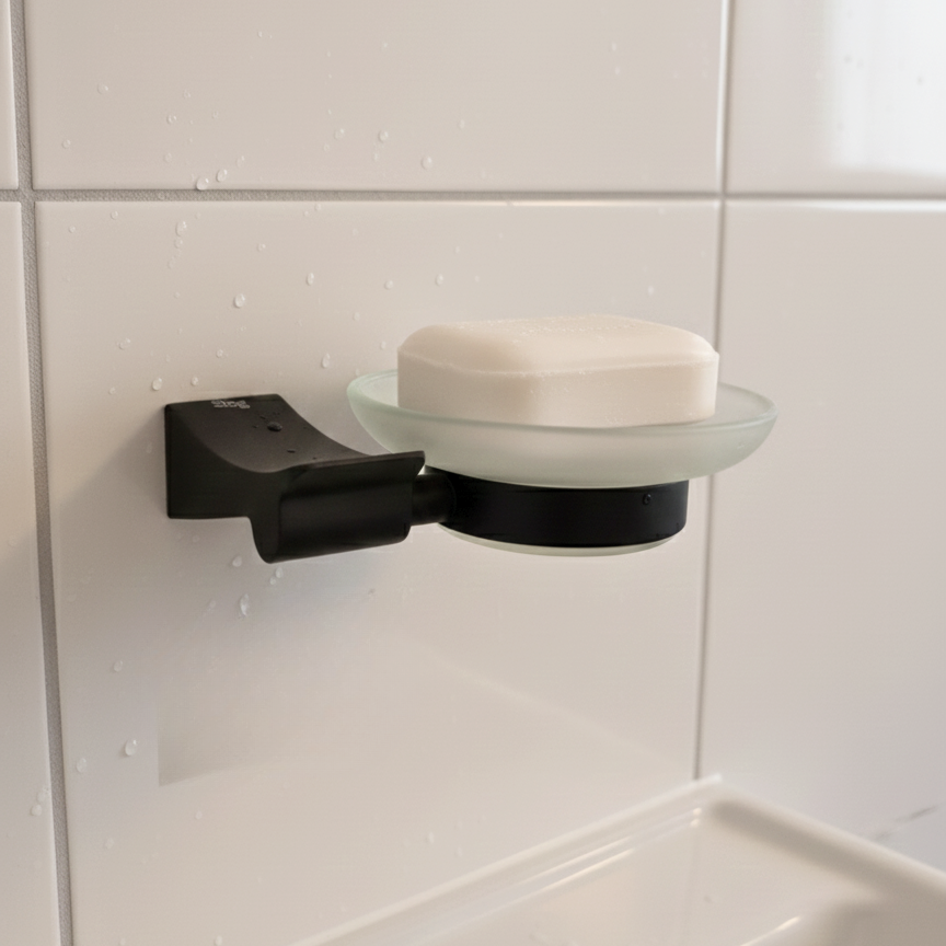 Black soap holder with a bar of soap on a tiled bathroom wall.
