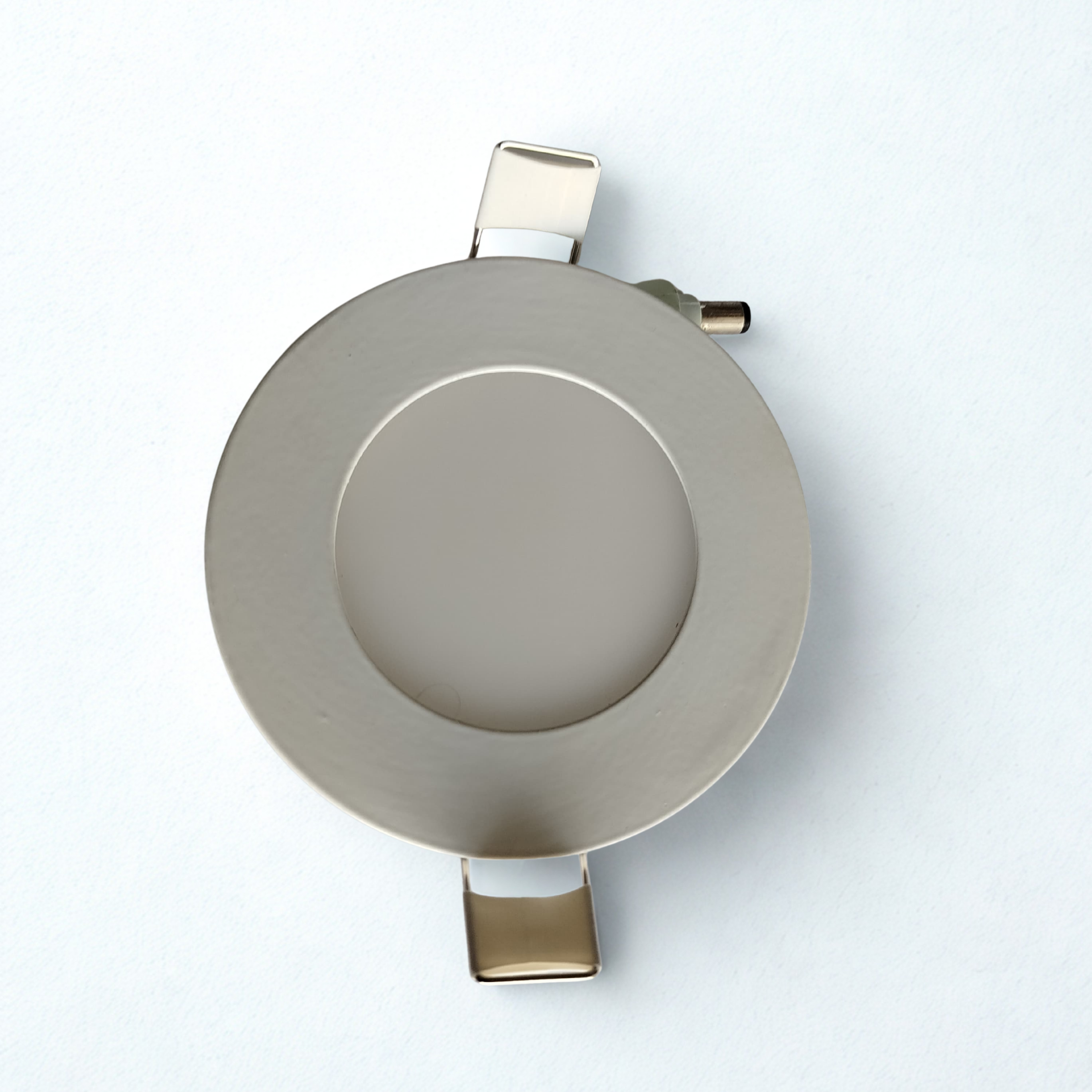 Round metallic object on a white background