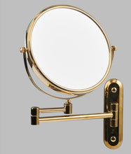 Load image into Gallery viewer, A gold-colored extendable magnifying wall mirror with a brass and stainless steel construction, mounted on a wall bracket.
