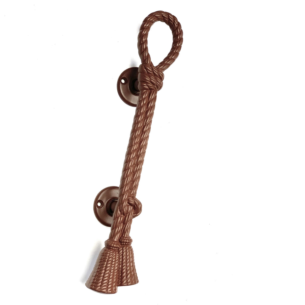 A large brown door pull with a rope-like handle and a tassel-like end.