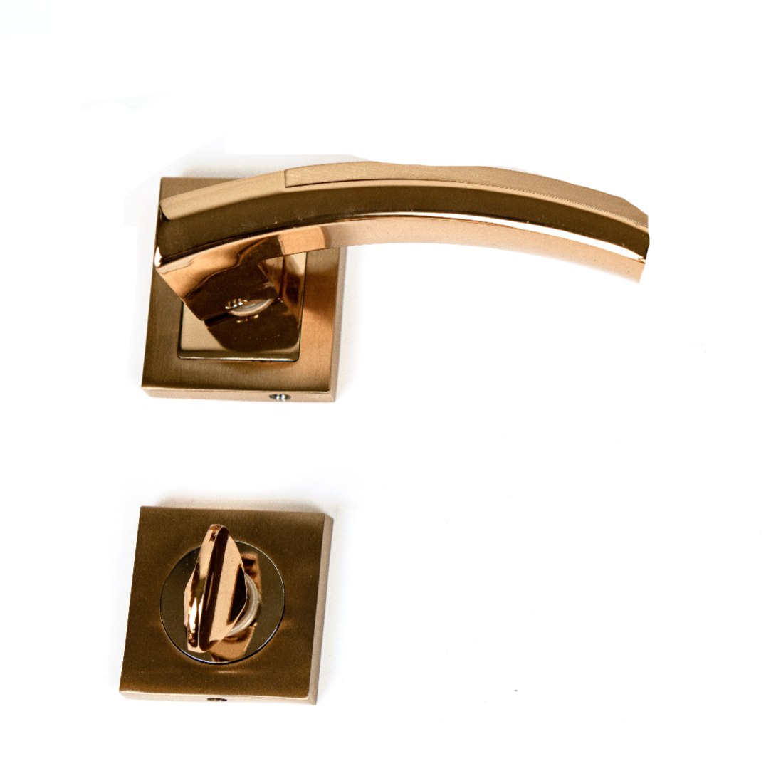 A pair of door handles with a gold-colored finish and a circular mounting plate.