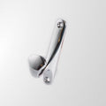 A single silver metal hook mounted on a white wall.